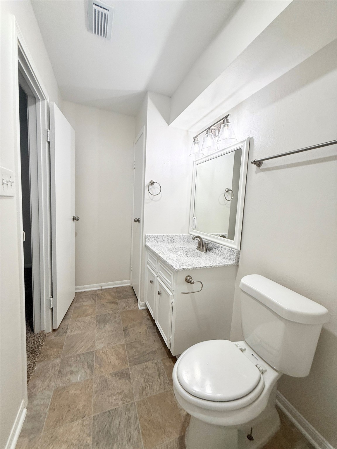 1497 Springrock Lane Houston, TX 77055 - Photo 17 of 23 a bathroom with a granite countertop toilet a sink and a mirror