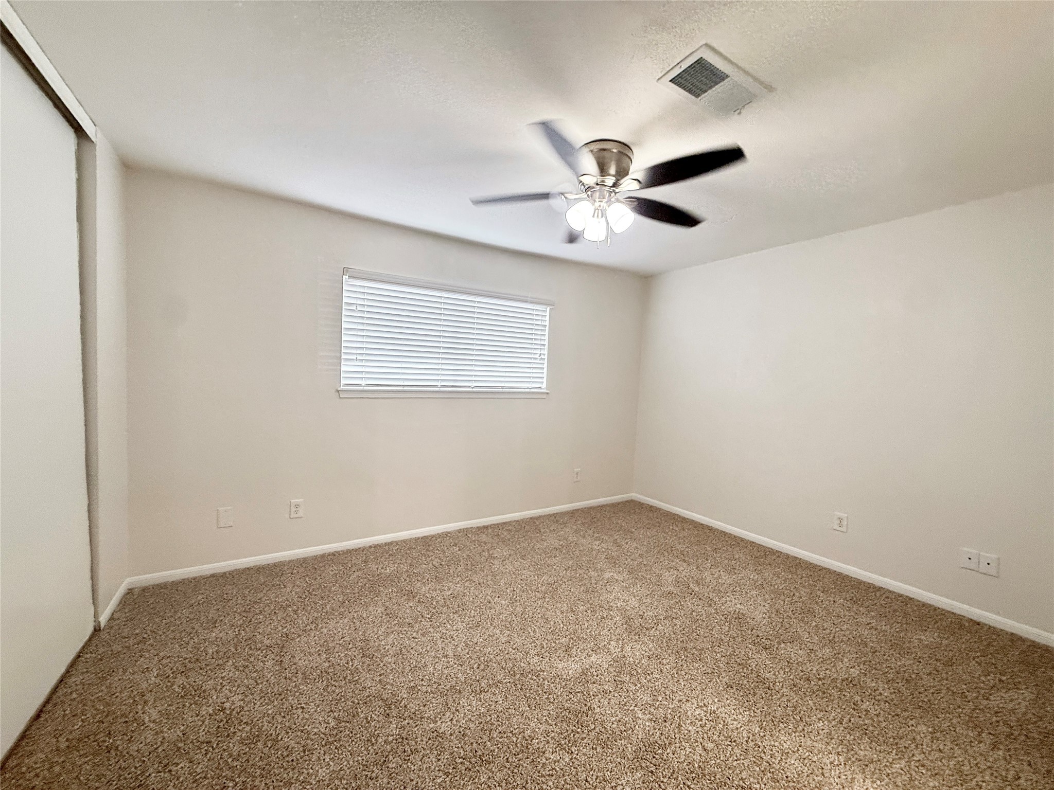 1497 Springrock Lane Houston, TX 77055 - Photo 19 of 23 an empty room with windows and fan