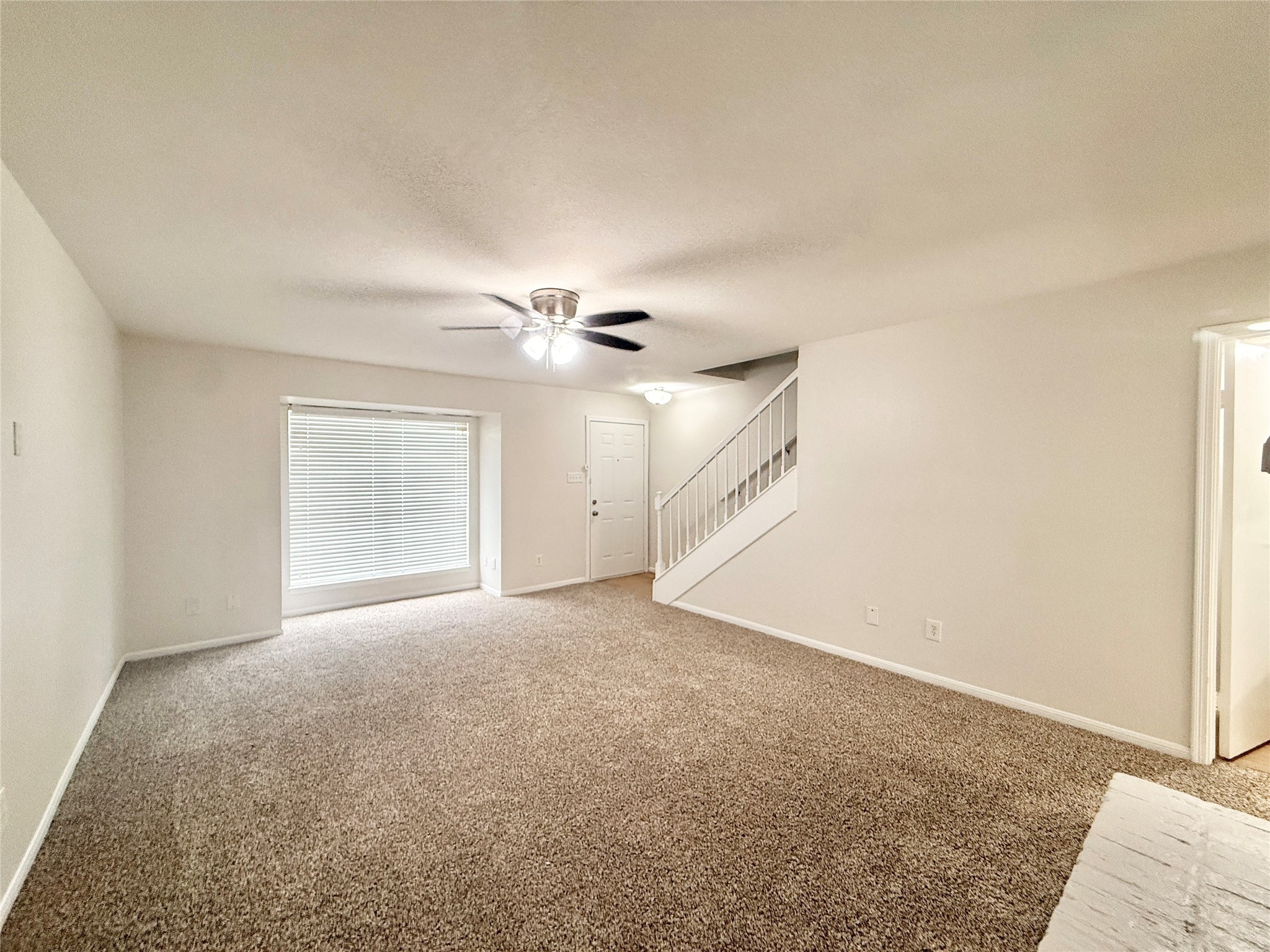1497 Springrock Lane Houston, TX 77055 - Photo 2 of 23 an empty room with a ceiling fan and a rug