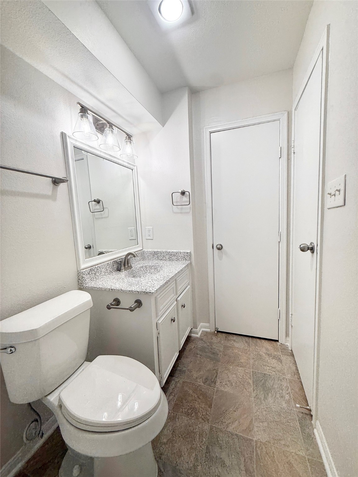 1497 Springrock Lane Houston, TX 77055 - Photo 23 of 23 a bathroom with a granite countertop toilet a sink and a mirror