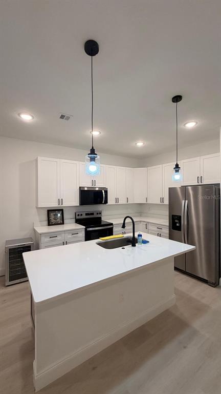 1597 Kerman Street North Port, FL 34288 - Photo 14 of 26 a large white kitchen with a sink a stove a refrigerator and a fireplace