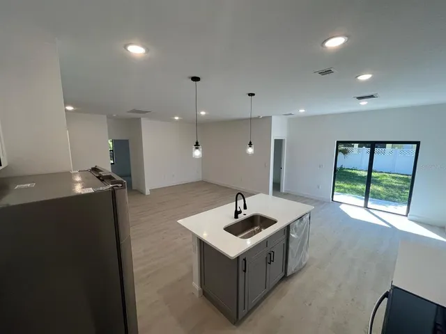 a kitchen with stainless steel appliances granite countertop a sink and a refrigerator