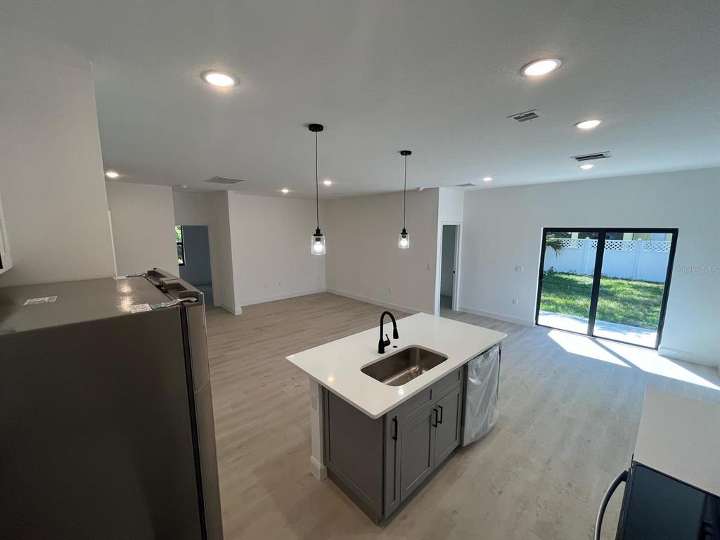1597 Kerman Street North Port, FL 34288 - Photo 7 of 26 a kitchen with stainless steel appliances granite countertop a sink and a refrigerator