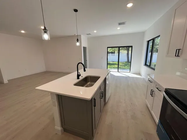 a kitchen with a sink a large window and stainless steel appliances