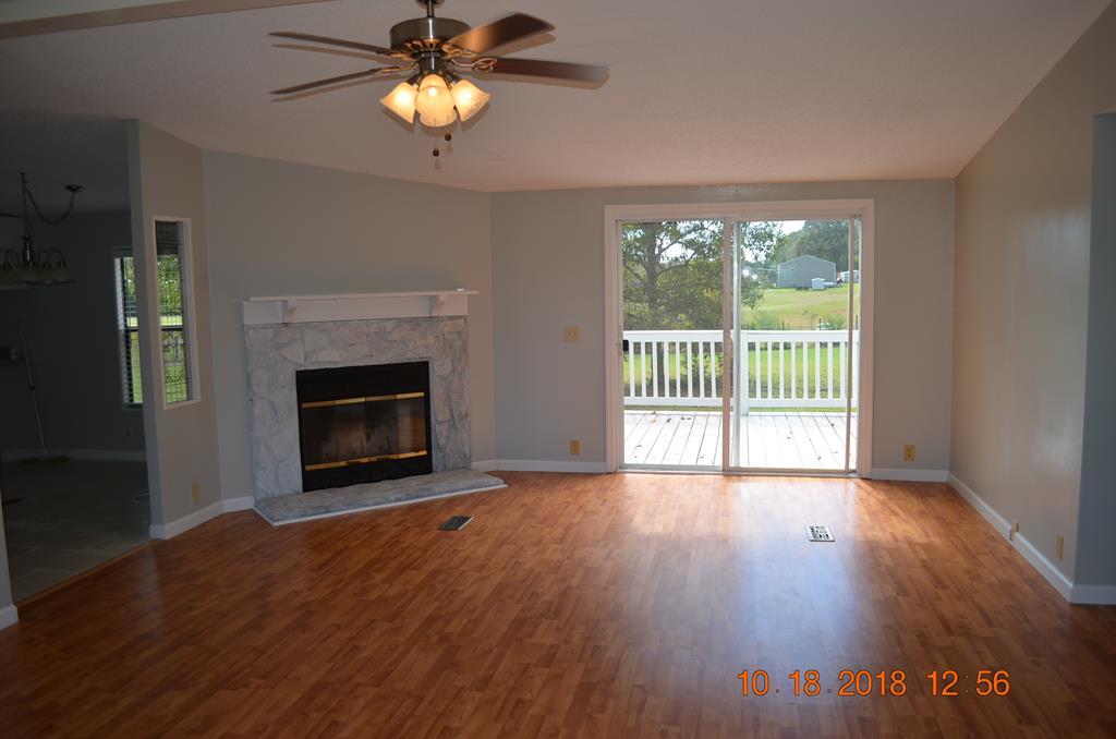 1055 Burnett Road Byron, GA 31008 - Photo 12 of 23 a view of empty room with wooden floor and fireplace