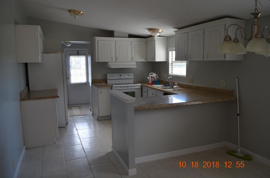1055 Burnett Road Byron, GA 31008 - Photo 7 of 23 a kitchen with stainless steel appliances a sink a stove a refrigerator and cabinets