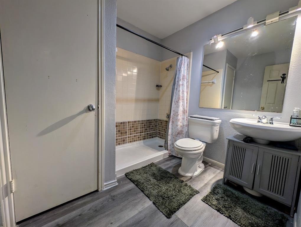 1901 Bosque Lane Arlington, TX 76006 - Photo 12 of 13 a bathroom with a toilet a sink and a mirror