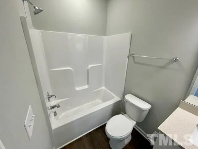 a white toilet sitting next to a bath tub