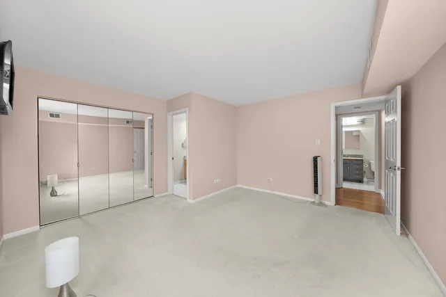 an empty room with glass door and shower