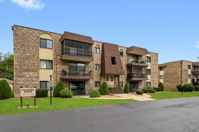 a front view of a building with a garden and plants