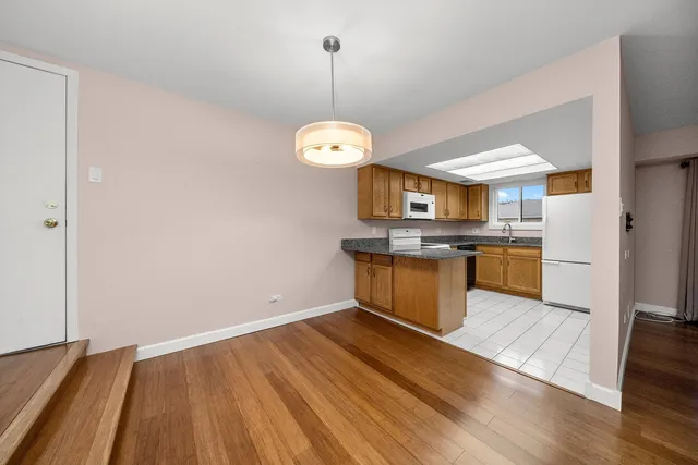 a kitchen with stainless steel appliances granite countertop a sink cabinets and wooden floor