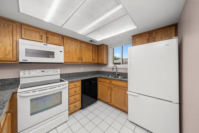 a kitchen with granite countertop cabinets stainless steel appliances and a counter space