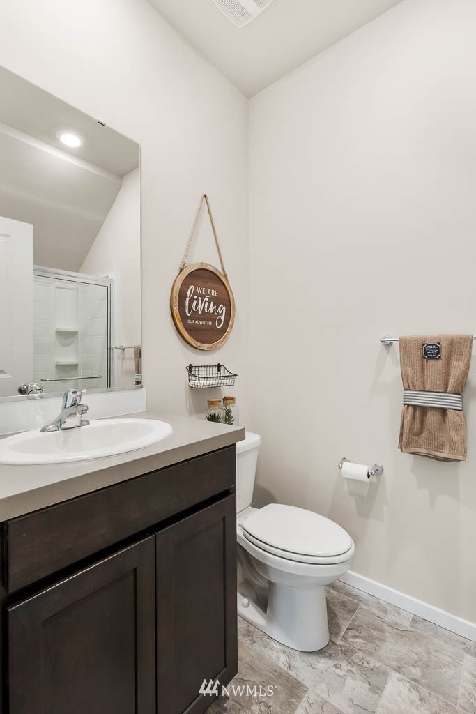 21119 Meridian Drive Southeast, Unit P21 Bothell, WA 98021 - Photo 5 of 31 a bathroom with a toilet a sink and mirror