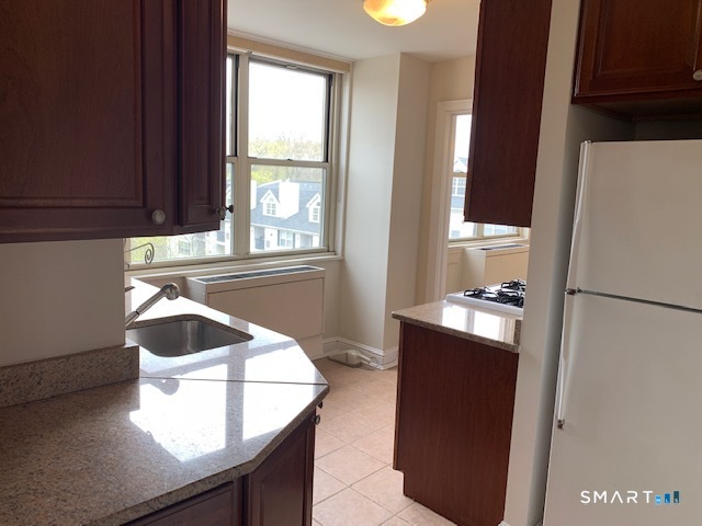 50 Glenbrook Road, Unit 5G Stamford, CT 06902 - Photo 20 of 40 a kitchen with a refrigerator and a window