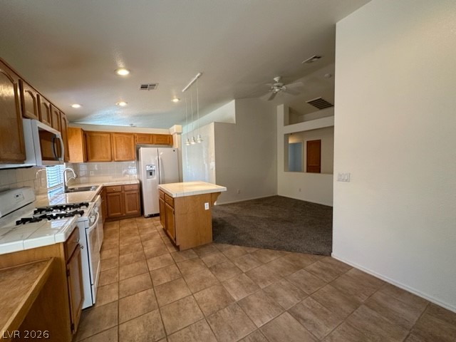285 Spring Palms Street Henderson, NV 89012 - Photo 8 of 38 Kitchen featuring ceiling fan, tile countertops, white appliances, and visible vents