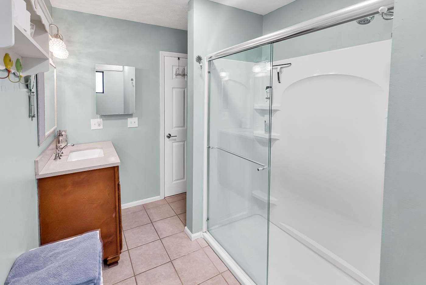 724 Juniper Drive, Unit B Surfside Beach, SC 29575 - Photo 22 of 36 Full bathroom with a stall shower, vanity, and light tile patterned flooring