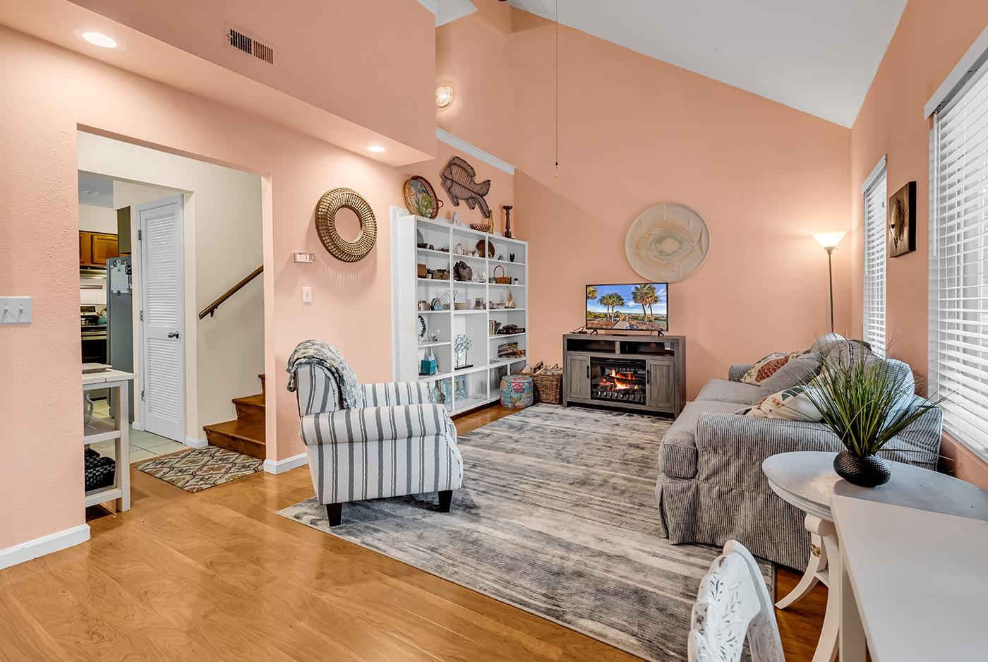 724 Juniper Drive, Unit B Surfside Beach, SC 29575 - Photo 5 of 36 Living area featuring light wood-style floors, stairs, a warm lit fireplace, and high vaulted ceiling