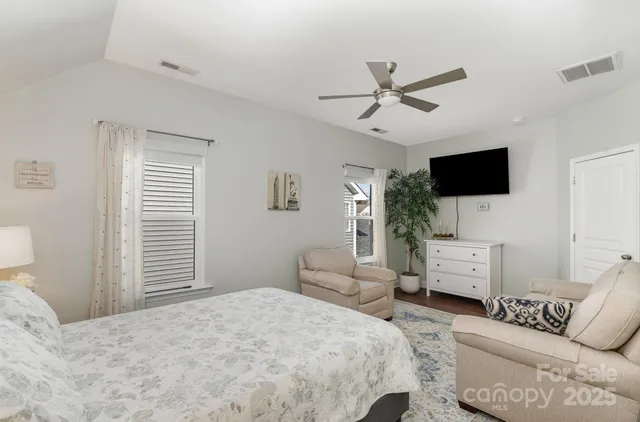 a bedroom with a bed and a flat tv screen on the dresser