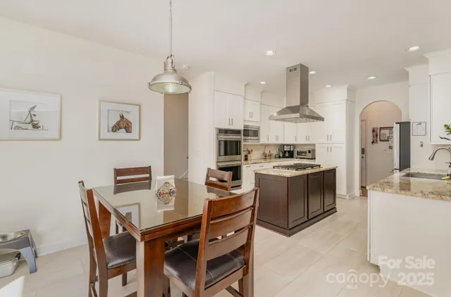 a kitchen with stainless steel appliances kitchen island granite countertop a stove and a sink