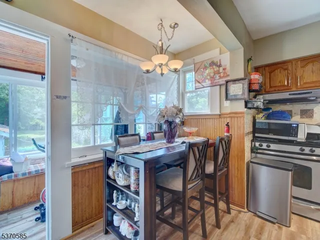 a view of a dining room with furniture a chandelier and wooden floor