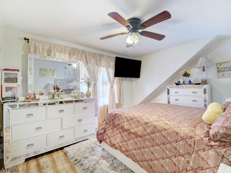 73 South Maple Avenue Springfield, NJ 07081 - Photo 19 of 26 a spacious bedroom with a bed and a flat screen tv