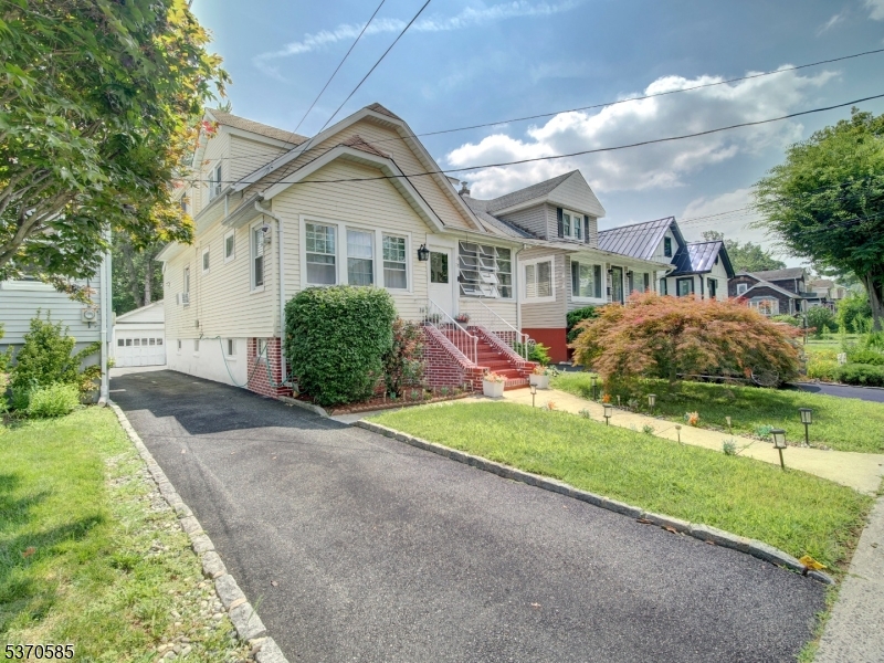 73 South Maple Avenue Springfield, NJ 07081 - Photo 2 of 26 a front view of a house with a yard and garage