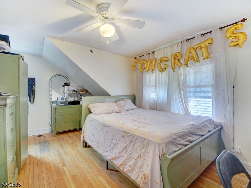 73 South Maple Avenue Springfield, NJ 07081 - Photo 21 of 26 a bedroom with a bed and a dresser with wooden floor