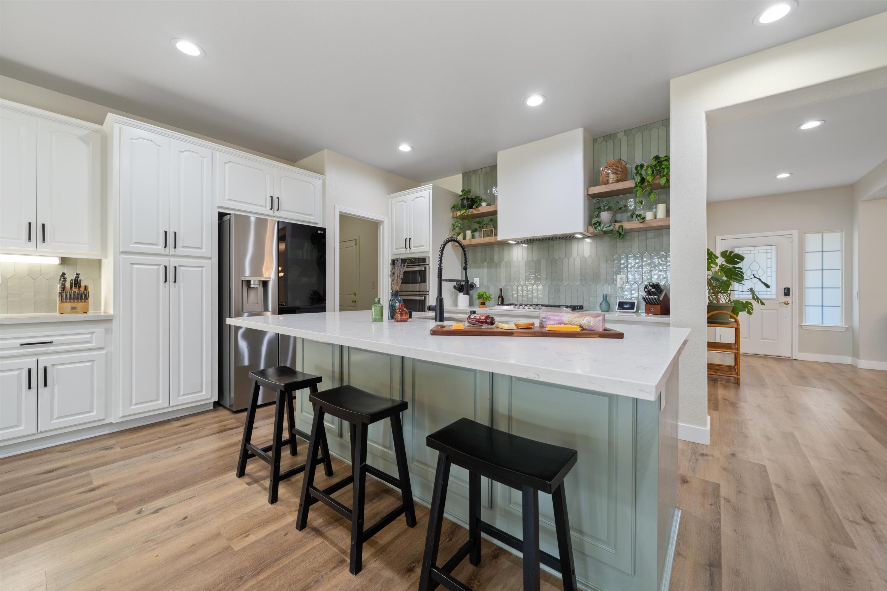 19475 Spalding Avenue Riverside, CA 92508 - Photo 3 of 50 a kitchen with stainless steel appliances a dining table chairs refrigerator and sink