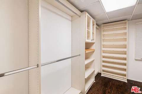 a view of walk in closet with empty racks