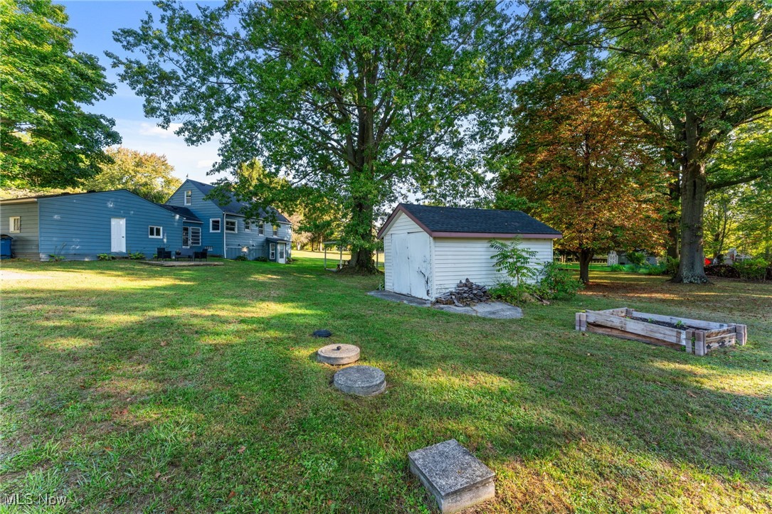 35221 Chestnut Ridge Road North Ridgeville, OH 44039 - Photo 19 of 48 View of green lawn featuring a shed, view of scattered trees, and a garden