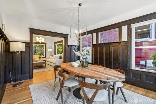 a dining room with furniture a chandelier and wooden floor