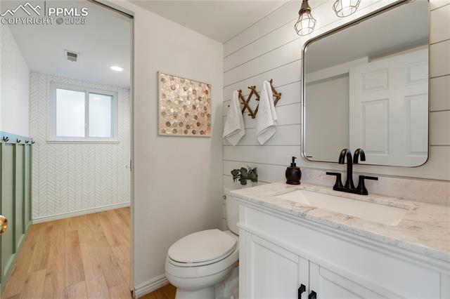 7827 Swiftrun Road Colorado Springs, CO 80920 - Photo 31 of 48 Bathroom with visible vents, baseboards, toilet, wood finished floors, and vanity