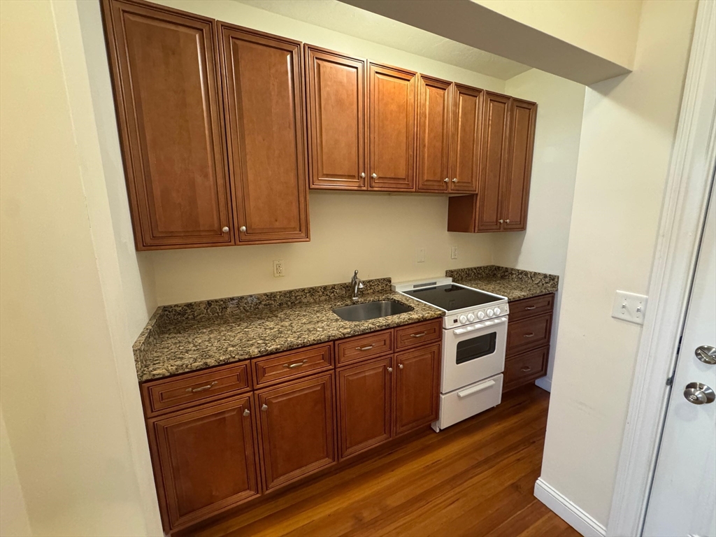 a kitchen with stainless steel appliances granite countertop a stove a sink and a microwave