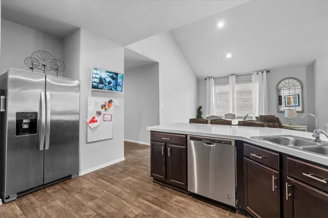 a kitchen with stainless steel appliances granite countertop a refrigerator and a sink
