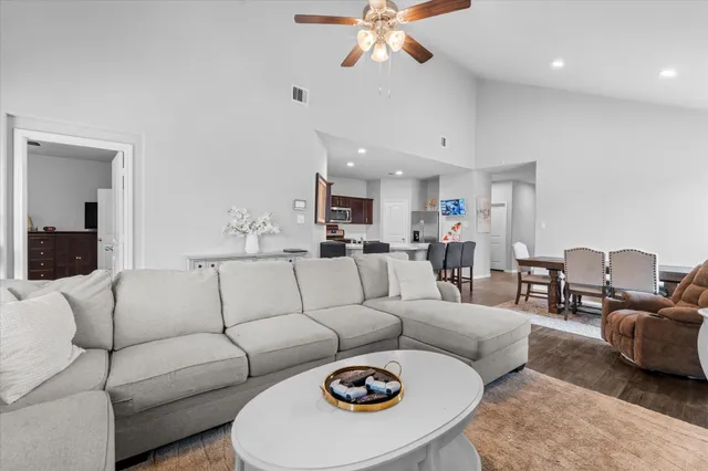 a living room with furniture and a view of kitchen