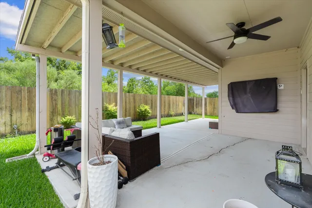a living room with patio furniture and a floor to ceiling window