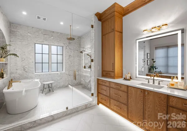a spacious bathroom with a double vanity sink toilet mirror and bathtub