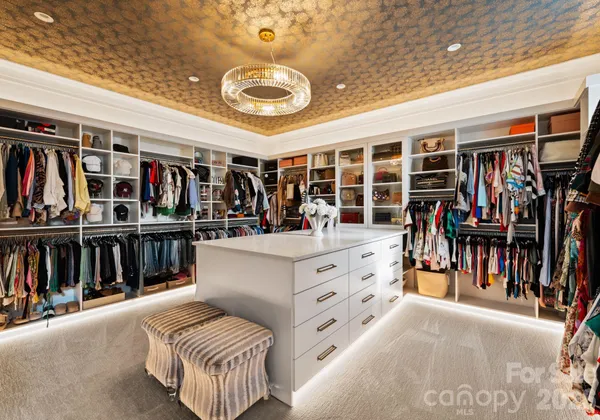 a view of walk in closet with clothes and shoes