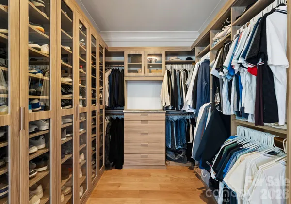a view of walk in closet with clothes and shoes