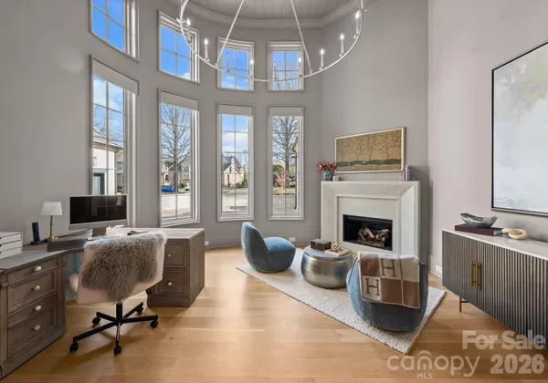 a living room with furniture a fireplace and a chandelier