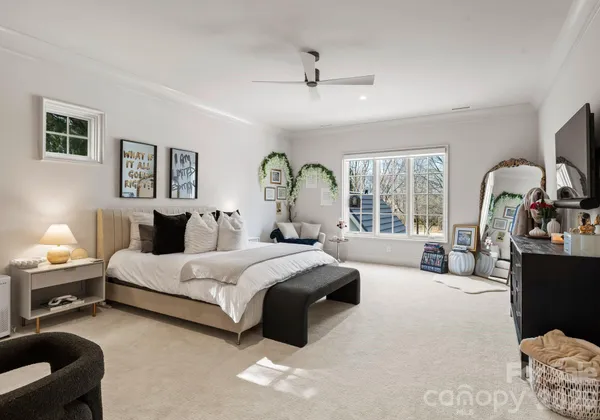 a spacious bedroom with a bed a couch and dresser