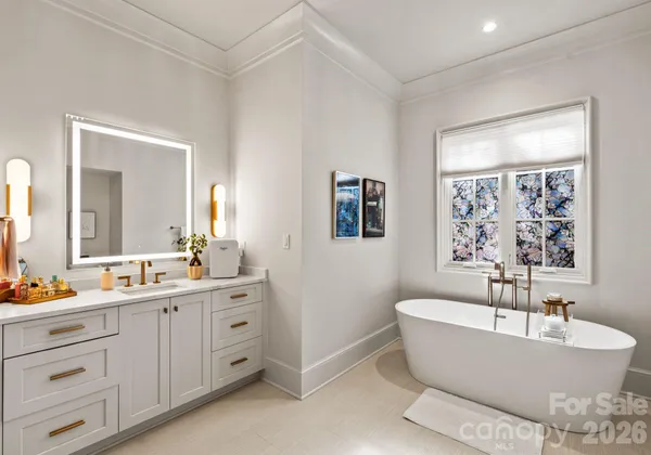 a bathroom with a tub a sink and mirror