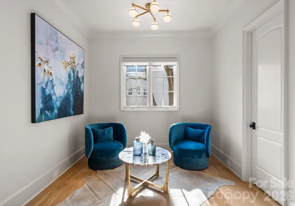 a living room with furniture and a painting on the wall