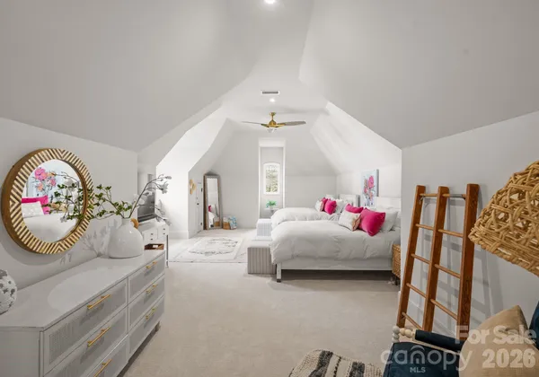 a bedroom with a bed and a large mirror on the dresser