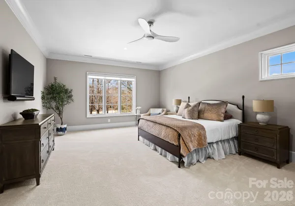 a spacious bedroom with a bed and a flat screen television