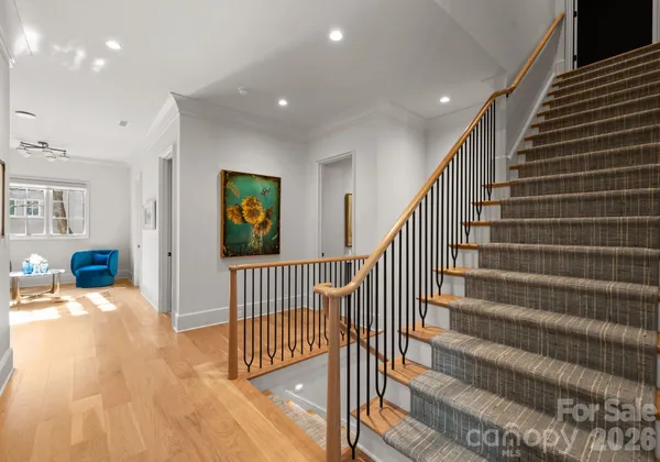 a view of a hallway with wooden floor and windows