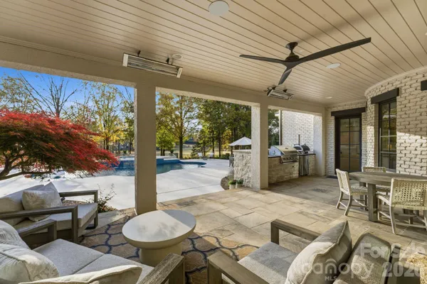 a view of swimming pool with a table and chairs under an umbrella