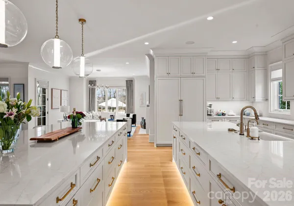 a large kitchen with stainless steel appliances lots of counter space and wooden floor