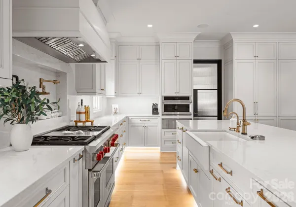 a kitchen with kitchen island stainless steel appliances a sink stove and cabinets