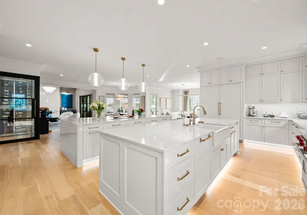 a large white kitchen with a large counter top appliances and cabinets